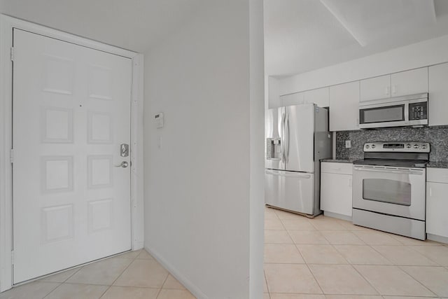5874 Crystal Shores Dr Unit 308, Boynton Beach, FL 33437 - kitchen featuring appliances with stainless steel finishes, white cabinets, light tile patterned floors, and backsplash