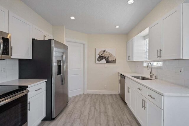 kitchen featuring white cabinetry, appliances with stainless steel finishes, and a sink