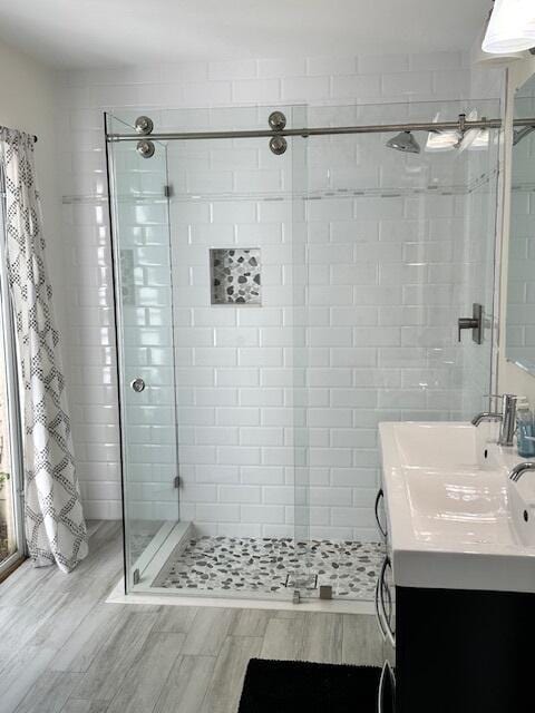 bathroom with a stall shower, wood finished floors, and vanity