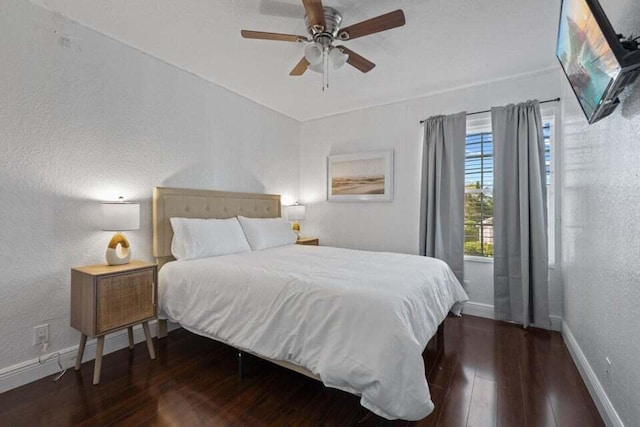 bedroom featuring a textured wall, hardwood / wood-style flooring, and baseboards