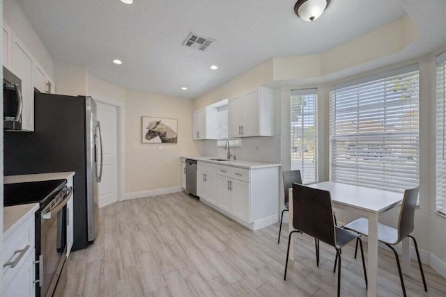 kitchen with light countertops, visible vents, stainless steel appliances, and baseboards