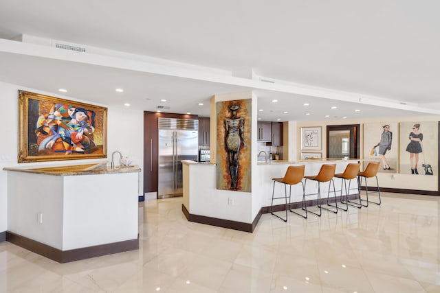 300 SE 5th Ave Unit 2050, Boca Raton, FL 33432 - interior space with a peninsula, stainless steel built in refrigerator, recessed lighting, a kitchen bar, and baseboards