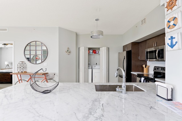 255 NE 3rd Ave Unit 2501, Delray Beach, FL 33444 - kitchen with a sink, appliances with stainless steel finishes, visible vents, dark brown cabinetry, and washer and clothes dryer