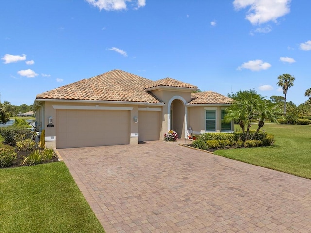 6000 Venetto Way, Vero Beach, FL 32967 - mediterranean / spanish home featuring a tile roof, decorative driveway, a front yard, an attached garage, and stucco siding