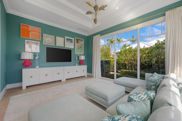 living area featuring crown molding, baseboards, wood finished floors, and a tray ceiling