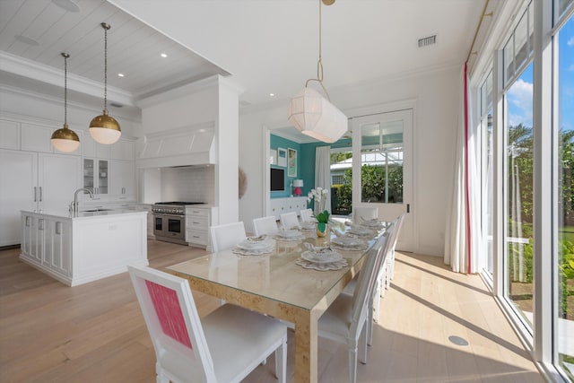 dining space featuring crown molding, light wood-style floors, recessed lighting, and visible vents