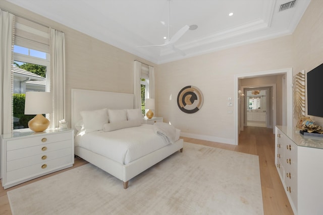 bedroom with baseboards, visible vents, ornamental molding, and light wood-type flooring