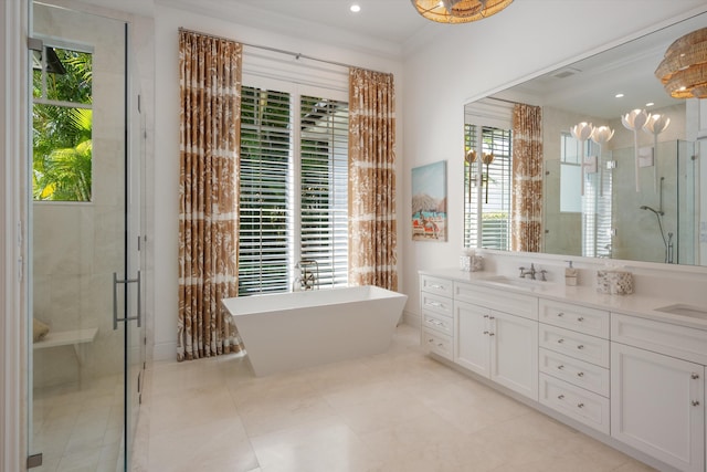 bathroom with double vanity, a freestanding bath, a stall shower, a sink, and ornamental molding