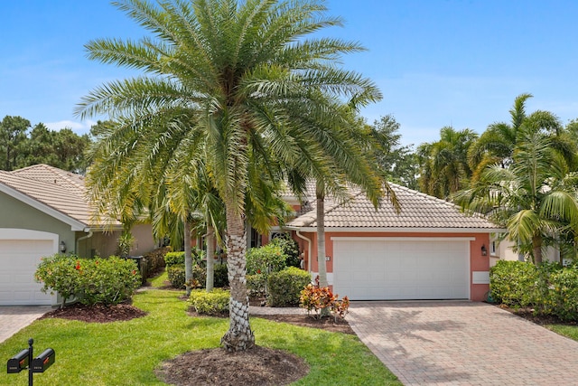 view of property hidden behind natural elements featuring an attached garage, decorative driveway, stucco siding, and a tiled roof