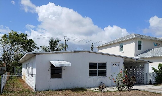 view of side of property with fence and stucco siding