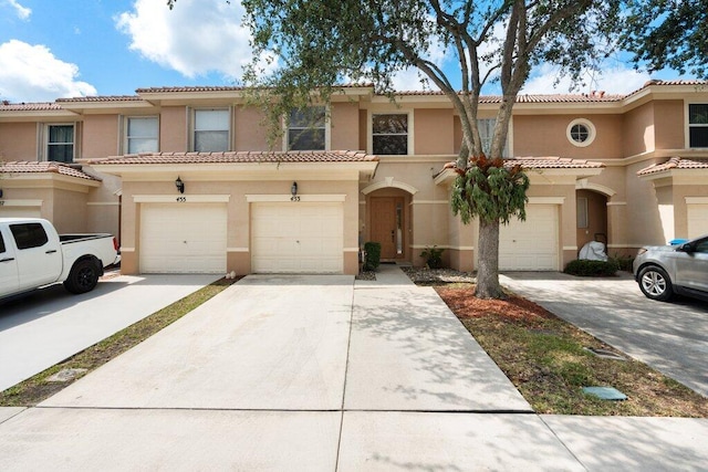 453 Rainbow Springs Ter, Royal Palm Beach, FL 33411 - view of property with stucco siding, driveway, an attached garage, and a tiled roof