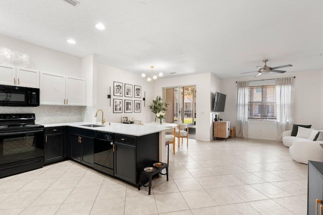453 Rainbow Springs Ter, Royal Palm Beach, FL 33411 - kitchen with black appliances, a sink, open floor plan, a peninsula, and decorative backsplash
