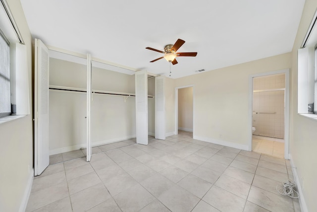 unfurnished bedroom with a ceiling fan, baseboards, light tile patterned floors, ensuite bathroom, and visible vents