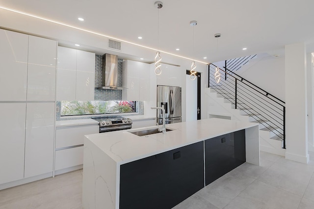 kitchen with modern cabinets, a spacious island, wall chimney range hood, a sink, and appliances with stainless steel finishes