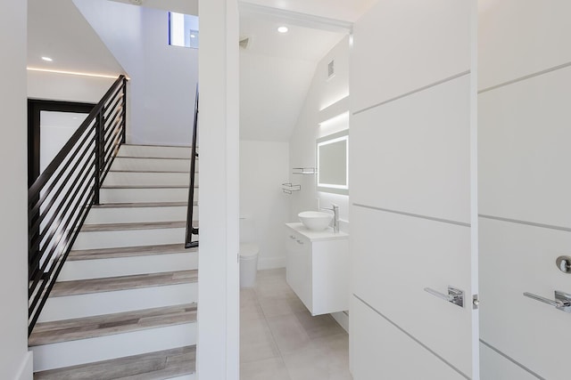 staircase with tile patterned flooring and lofted ceiling