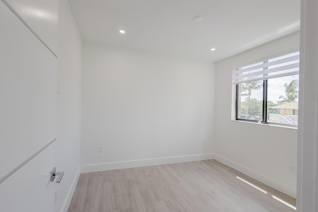 empty room with light wood-type flooring, recessed lighting, and baseboards