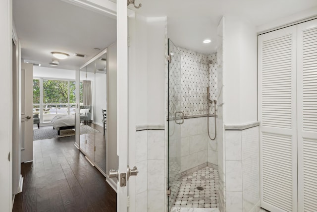 4201 N Ocean Blvd Unit 208, Boca Raton, FL 33431 - ensuite bathroom featuring visible vents, wainscoting, a shower stall, connected bathroom, and hardwood / wood-style floors