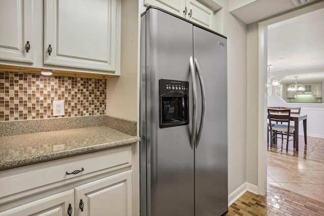 4201 N Ocean Blvd Unit 208, Boca Raton, FL 33431 - kitchen with stainless steel refrigerator with ice dispenser, tasteful backsplash, light stone countertops, baseboards, and an inviting chandelier