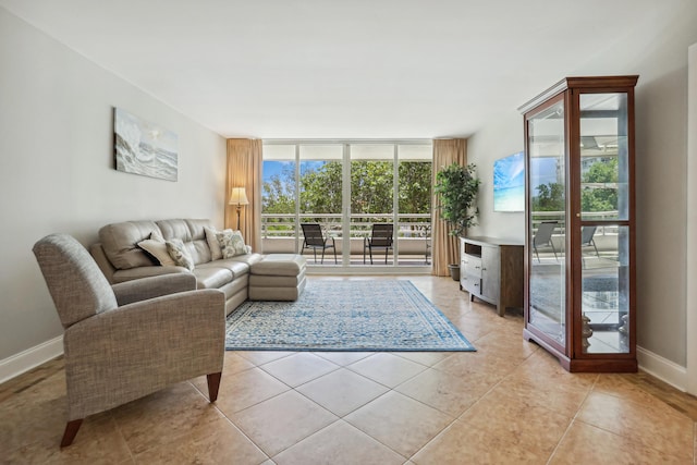 4201 N Ocean Blvd Unit 208, Boca Raton, FL 33431 - living area featuring baseboards, a wall of windows, and light tile patterned floors