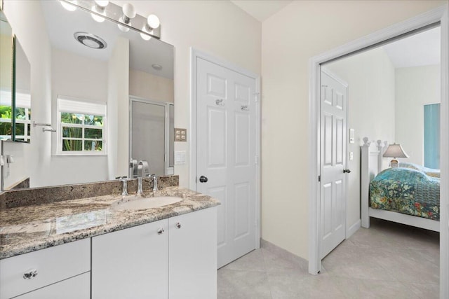 ensuite bathroom featuring vanity, baseboards, ensuite bathroom, tile patterned floors, and a shower stall
