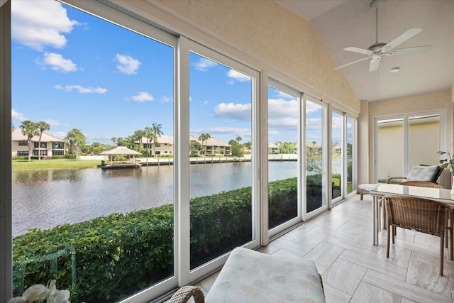 sunroom with a water view, vaulted ceiling, and a residential view