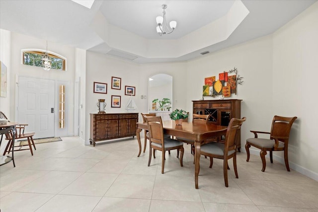 dining area featuring light tile patterned flooring, a notable chandelier, arched walkways, baseboards, and visible vents