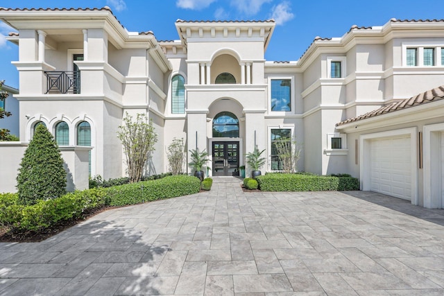 7339 NW 28th Way, Boca Raton, FL 33496 - mediterranean / spanish home with stucco siding, a tiled roof, decorative driveway, a garage, and french doors