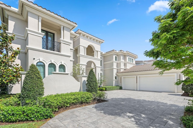 7339 NW 28th Way, Boca Raton, FL 33496 - mediterranean / spanish-style house with stucco siding, decorative driveway, a tiled roof, and an attached garage