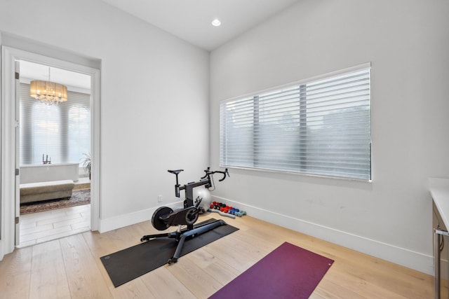 7339 NW 28th Way, Boca Raton, FL 33496 - exercise area featuring an inviting chandelier, a wealth of natural light, light wood-type flooring, and baseboards