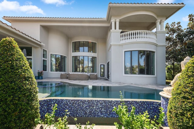 7339 NW 28th Way, Boca Raton, FL 33496 - rear view of house featuring a pool with connected hot tub, a patio area, a balcony, outdoor lounge area, and stucco siding