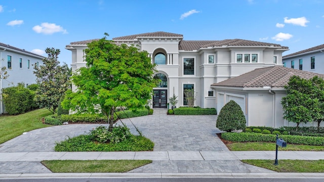 7339 NW 28th Way, Boca Raton, FL 33496 - mediterranean / spanish home featuring a tile roof, a garage, decorative driveway, stucco siding, and french doors