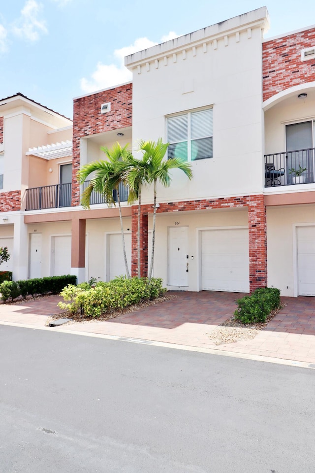 10520 SW Stephanie Way Unit 2204, Port Saint Lucie, FL 34987 - view of property with brick siding, decorative driveway, a garage, and stucco siding
