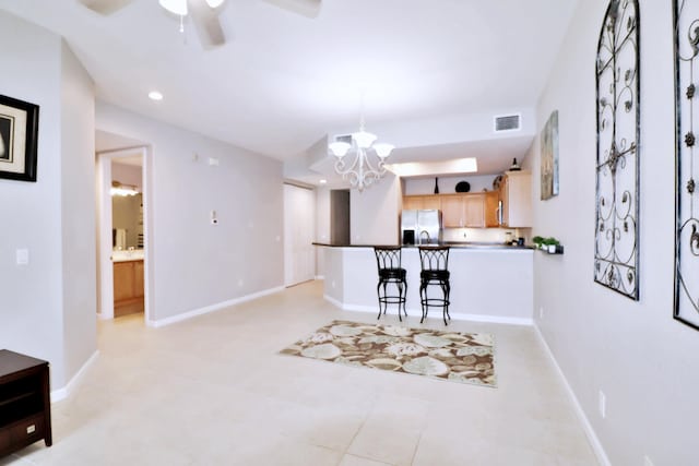 10520 SW Stephanie Way Unit 2204, Port Saint Lucie, FL 34987 - kitchen featuring visible vents, a peninsula, light brown cabinetry, stainless steel fridge, and ceiling fan with notable chandelier