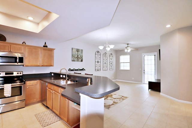 10520 SW Stephanie Way Unit 2204, Port Saint Lucie, FL 34987 - kitchen with a peninsula, baseboards, open floor plan, a sink, and stainless steel appliances