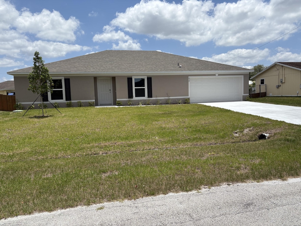 438 SW Meadow Ter, Port Saint Lucie, FL 34984 - ranch-style home featuring concrete driveway, stucco siding, a garage, and a front lawn