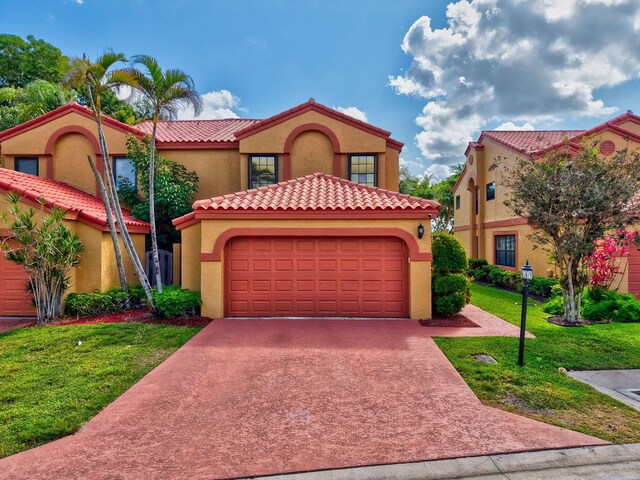 mediterranean / spanish house with a garage, stucco siding, a tiled roof, and a front yard