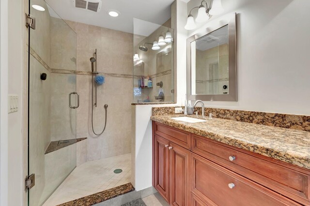 full bath with visible vents, a shower stall, and vanity
