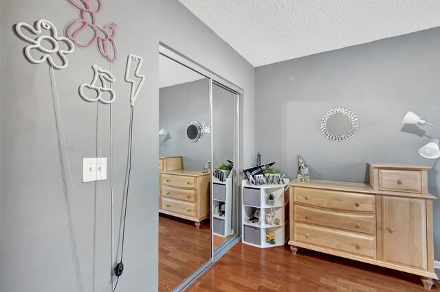 bedroom with a textured ceiling and dark wood-style floors