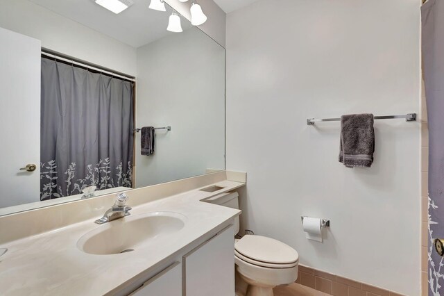 bathroom with toilet, a shower with curtain, and vanity