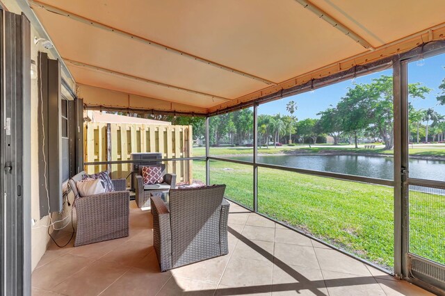 sunroom / solarium featuring a water view