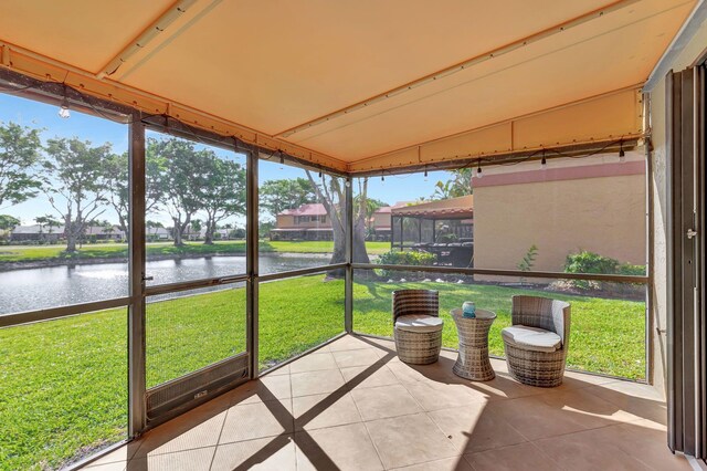 sunroom featuring a water view
