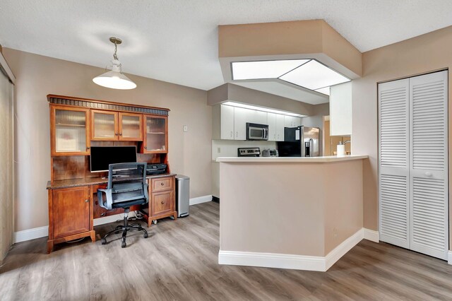 home office featuring baseboards and light wood finished floors