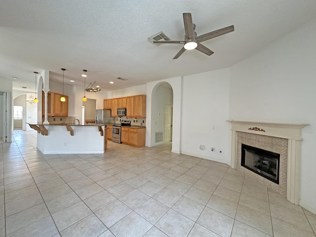 573 SW Saint Kitts St, Port Saint Lucie, FL 34953 - kitchen featuring appliances with stainless steel finishes, open floor plan, arched walkways, a kitchen bar, and recessed lighting