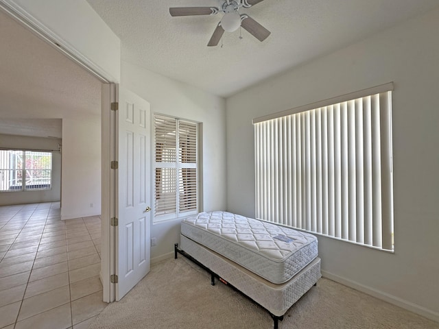 573 SW Saint Kitts St, Port Saint Lucie, FL 34953 - tiled bedroom featuring a textured ceiling, a ceiling fan, and carpet
