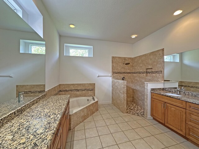 573 SW Saint Kitts St, Port Saint Lucie, FL 34953 - full bath featuring walk in shower, a garden tub, two vanities, tile patterned floors, and a textured ceiling