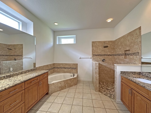 573 SW Saint Kitts St, Port Saint Lucie, FL 34953 - full bathroom featuring two vanities, a bath, walk in shower, tile patterned flooring, and a textured ceiling