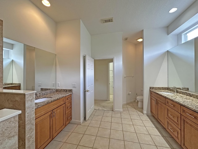 573 SW Saint Kitts St, Port Saint Lucie, FL 34953 - bathroom featuring two vanities, tile patterned floors, a textured ceiling, and recessed lighting