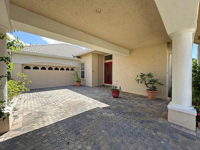573 SW Saint Kitts St, Port Saint Lucie, FL 34953 - view of patio with decorative driveway and an attached garage