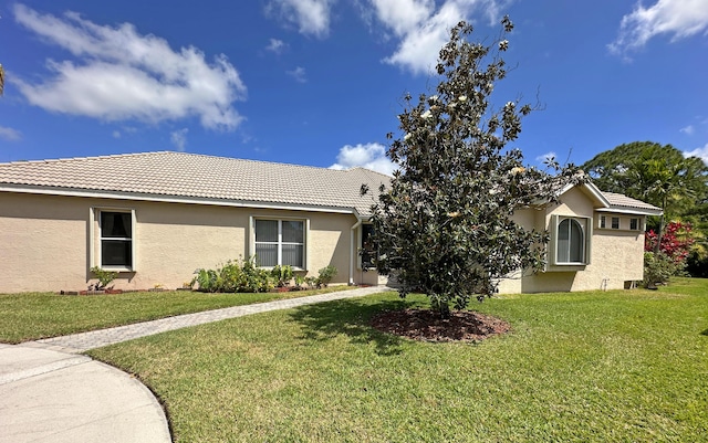 573 SW Saint Kitts St, Port Saint Lucie, FL 34953 - view of front of home featuring stucco siding, a tiled roof, and a front lawn