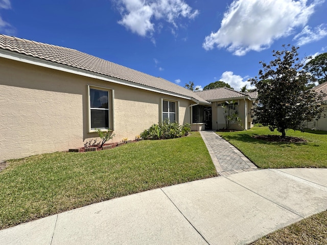 573 SW Saint Kitts St, Port Saint Lucie, FL 34953 - view of front of house with stucco siding, a front yard, and a tile roof